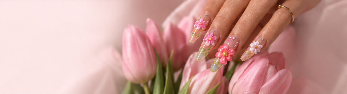 Hand wearing pink floral LAVIQO nails on a blush towel