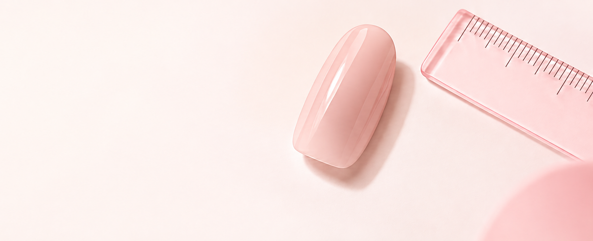 Translucent nude-pink press-on nail and pink ruler